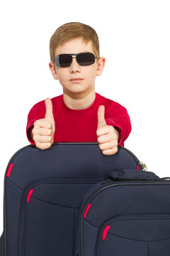 Portrait of boy with travel bags wearing sunglasses showing thum