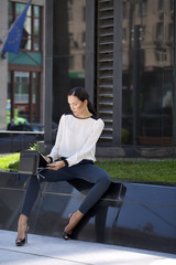 Beautiful business woman sitting on a bench