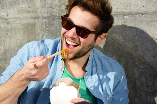 Cool Man Eating Chinese Takeaway With Chopsticks