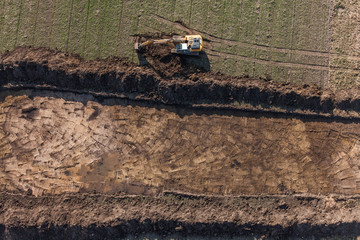 aerial view of long arm excavator working on the field