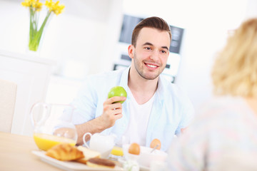 Happy couple eating breakfast