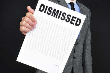 man in suit showing a document with the text dismissal