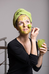 Young woman with an avocado facial mask