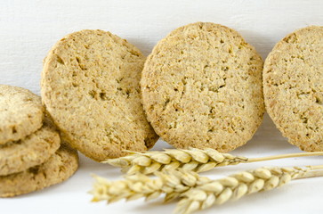 Integral cookies and wheat on white background