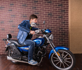Fototapeta na wymiar Young Man in Blue Jacket on his Sports Motorbike