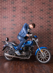 Obraz na płótnie Canvas Man mounting a motorbike indoors
