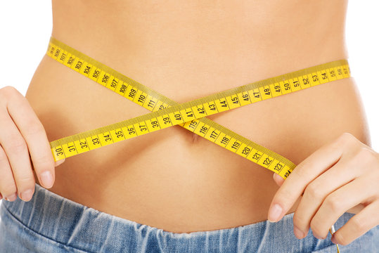 Slim woman measuring her waist.