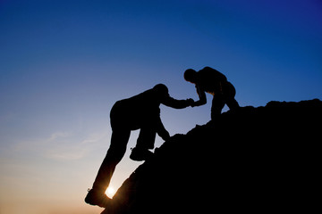 Silhouette of helping hand between two climber