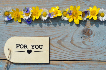 wooden background  with for you label and field flowers