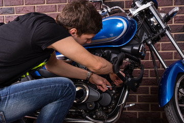 Obraz na płótnie Canvas Young Man Repairing his Motorcycle Manually