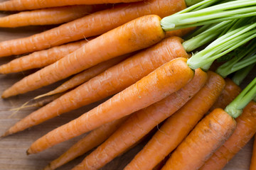 Fresh carrots on the wooden background.