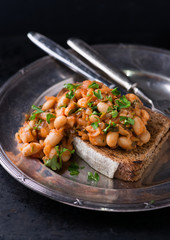 Stewed white beans in tomato sauce on toasted bread