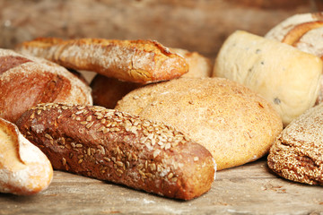Different fresh bread on old wooden table