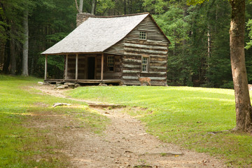 Old log farmhouse with a dirt path
