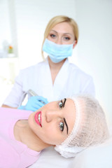 Naklejka premium Permanent make-up (tattoo) at beauty salon