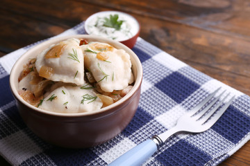 Tasty dumplings with fried onion in brown bowl,
