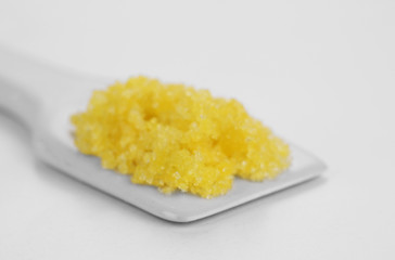 Laboratory spatula with granules isolated on white