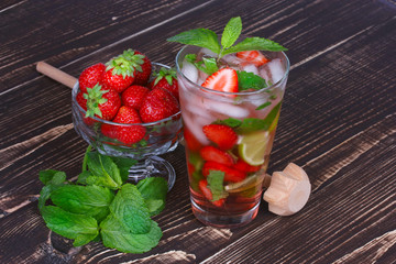 Strawberry mojito cocktail on wooden background