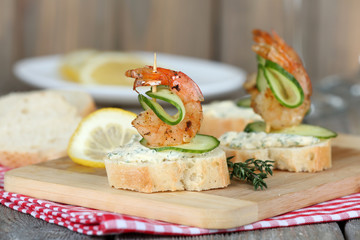 Appetizer canape with shrimp and cucumber on table close up