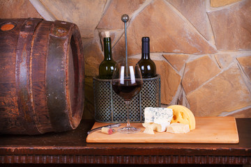 Glass and bottle of wine, cheese and prosciutto