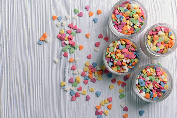Colorful sprinkles in bowls on table close-up