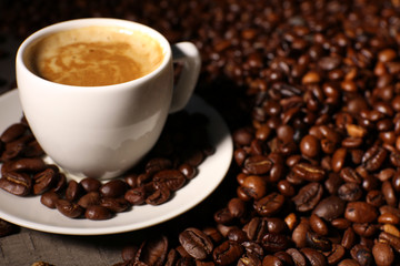 Cup of coffee with grains, closeup
