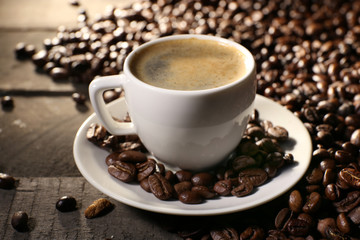 Cup of coffee with grains, closeup