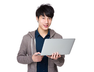 Young asian man holding laptop computer and work