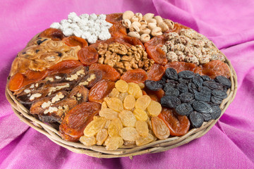 Assorted nuts and dried fruits in wicker plate
