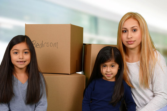 Mother with three kids and moving boxes