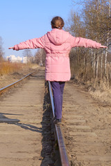 Girl balancing on railway tracks