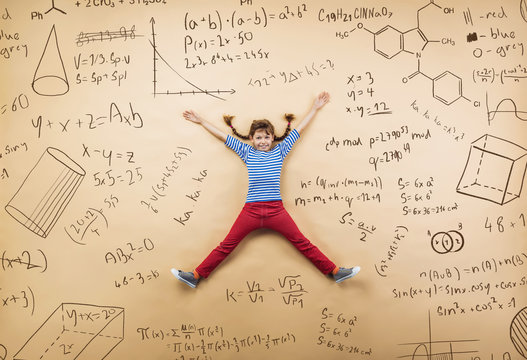 Cute little girl learning playfully in frot of a big blackboard