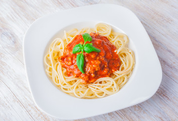 spaghetti bolognese in white bowl on wooden table