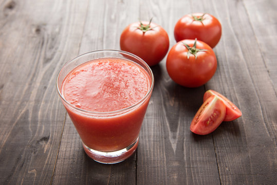 Healthy vegetable smoothie made of red ripe tomatoes on wooden t