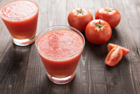 Healthy vegetable smoothie made of red ripe tomatoes on wooden t