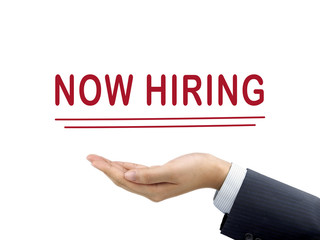 now hiring words holding by businessman's hand