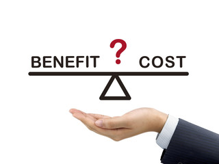 balance between benefit and cost holding by businessman's hand