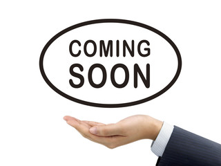 coming soon words holding by businessman's hand