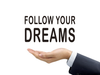 follow your dreams words holding by businessman's hand