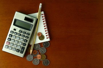 Coins, calculator, pencil and notebook