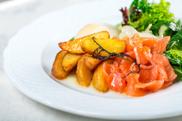 Potato wedges with sliced salmon