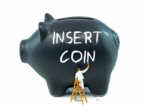 Financial savings concept with Insert Coin message on piggy bank