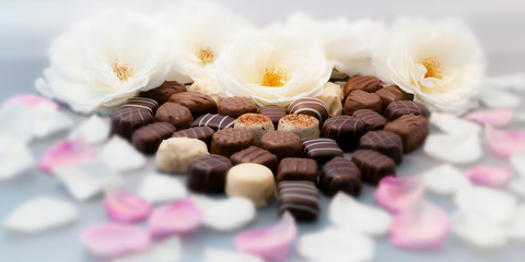 Fototapeta na wymiar Romantic chocolate truffles white roses heart horizontal