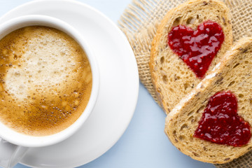 Fresh coffee. Grain slice of bread with jam heart shape.