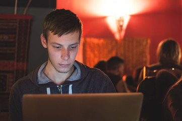 Student working on laptop in public place such as a bar or pub