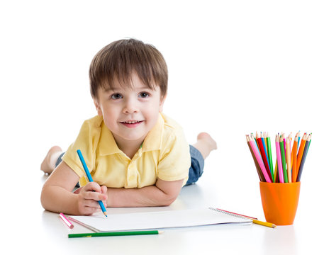 Cute child boy drawing with pencils in preschool isolated