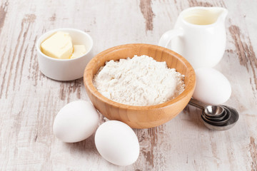 flour, butter and eggs for baking pancakes on wooden table
