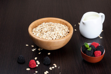 oatmeal in a bowl, fberries and milk on table