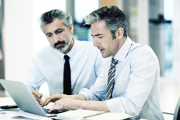 Businessmen working in office with laptop