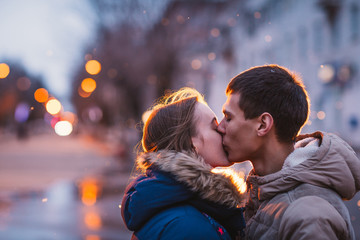 Portrait of young beautiful couple kissing in rain